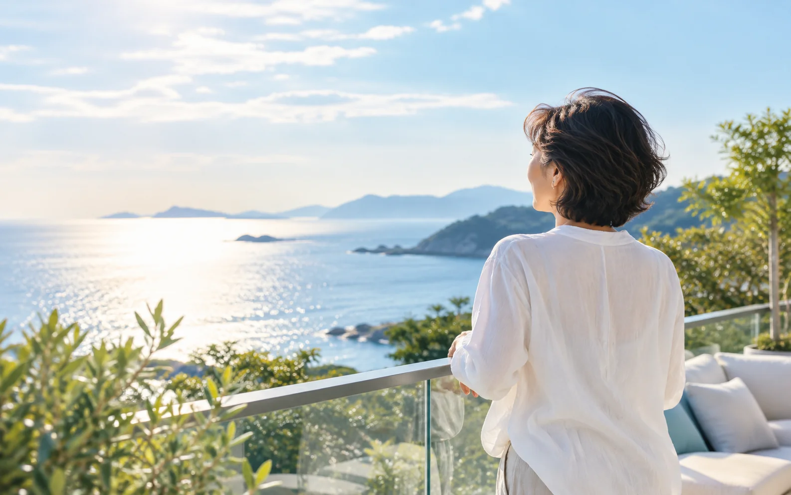 海と空を見渡すテラスで、未来を見つめる女性の後ろ姿